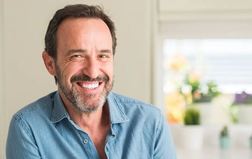 A middle-aged man in a blue button-up smiling